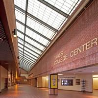 Red brick interior of the Tawes Center at Coppin State University where a yellow rectangular add value machine sits in the middle of the floor