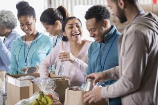 A group of happy people work together packing food for the needy