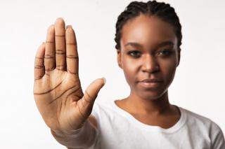 A female holding her palm facing forward in a stop gesture