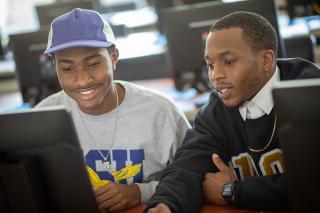 Two students in class using a computer