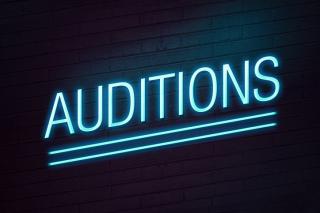 Blue neon sign with auditions text on wall