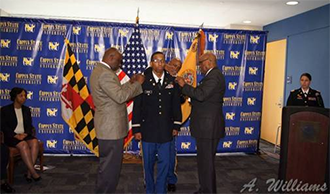 A Coppin State University ROTC Cadet being pinned by 2 military officers during an official Commissioning Ceremony