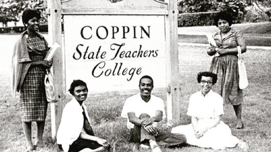 Group of 5 student posed around a Coppin State Teachers College sign in a black and white photo.