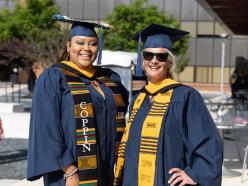 Two Coppin graduates smiling