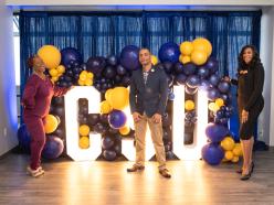 Alumni posing near CSU letters