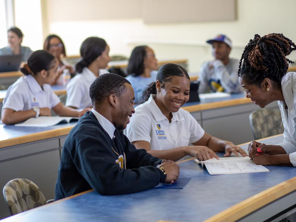a professor helps students during in-class instruction