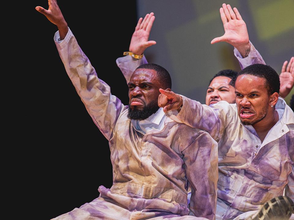 Fraternity brothers perform on stage during the Homecoming step show
