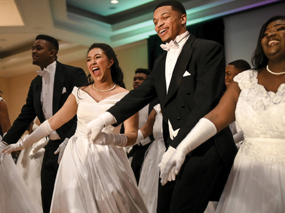 Stock image of males and females in tuxedos and long gowns