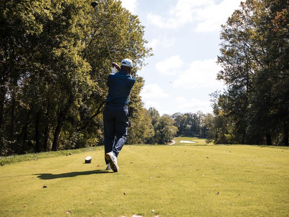President Jenkins hitting off tee at Coppin Golf Classic.