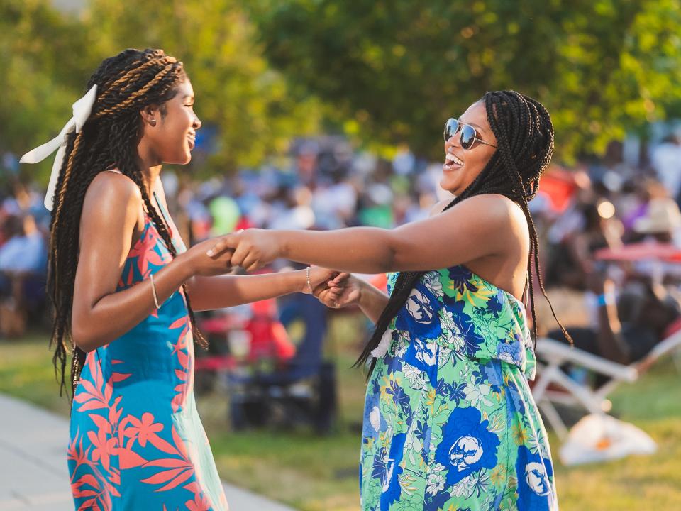 Two young women dancing together at the Coppin Summer Concert.