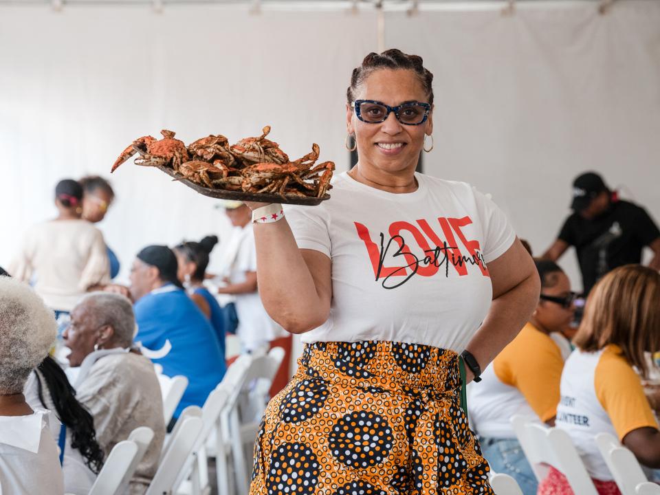 Alumni holding plate of steamed crabs.