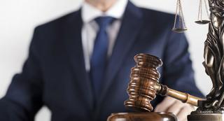 A man in a suit beside a gavel