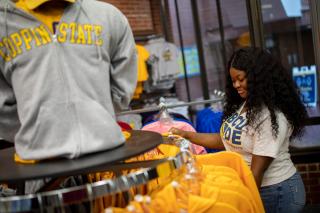 A female student shops for clothing in the Coppin campus bookstore