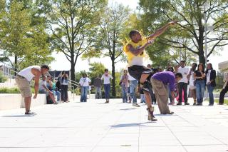 Fraternity members perform a step show in the campus quad