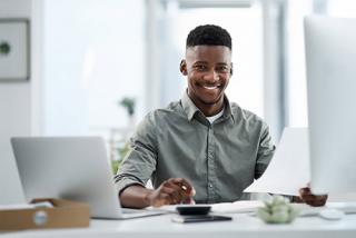 Man sitting around desk holding a sheet of paper