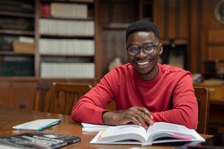 A Sociology student reading in the library