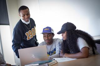 Coppin Students working together on a project using a laptop