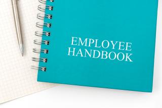 Employee Handbook or manual with a pen and paper on a white table in an office 