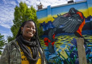 Devan poses in front of a Baltimore mural 