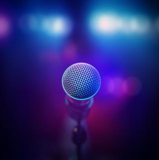 Microphone close-up from behind facing out of focus stage lights