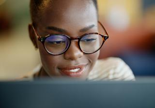 African American student smiles as she works on a computer
