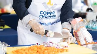 Person cutting vegetables during 2025 Coppin Chopped event.