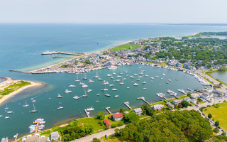 A beachfront shoreline with docks and boats on the water.