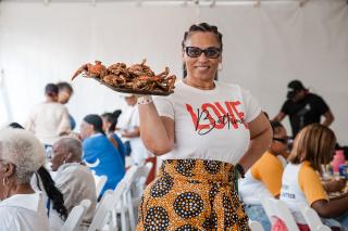 Alumni holding plate of steamed crabs.